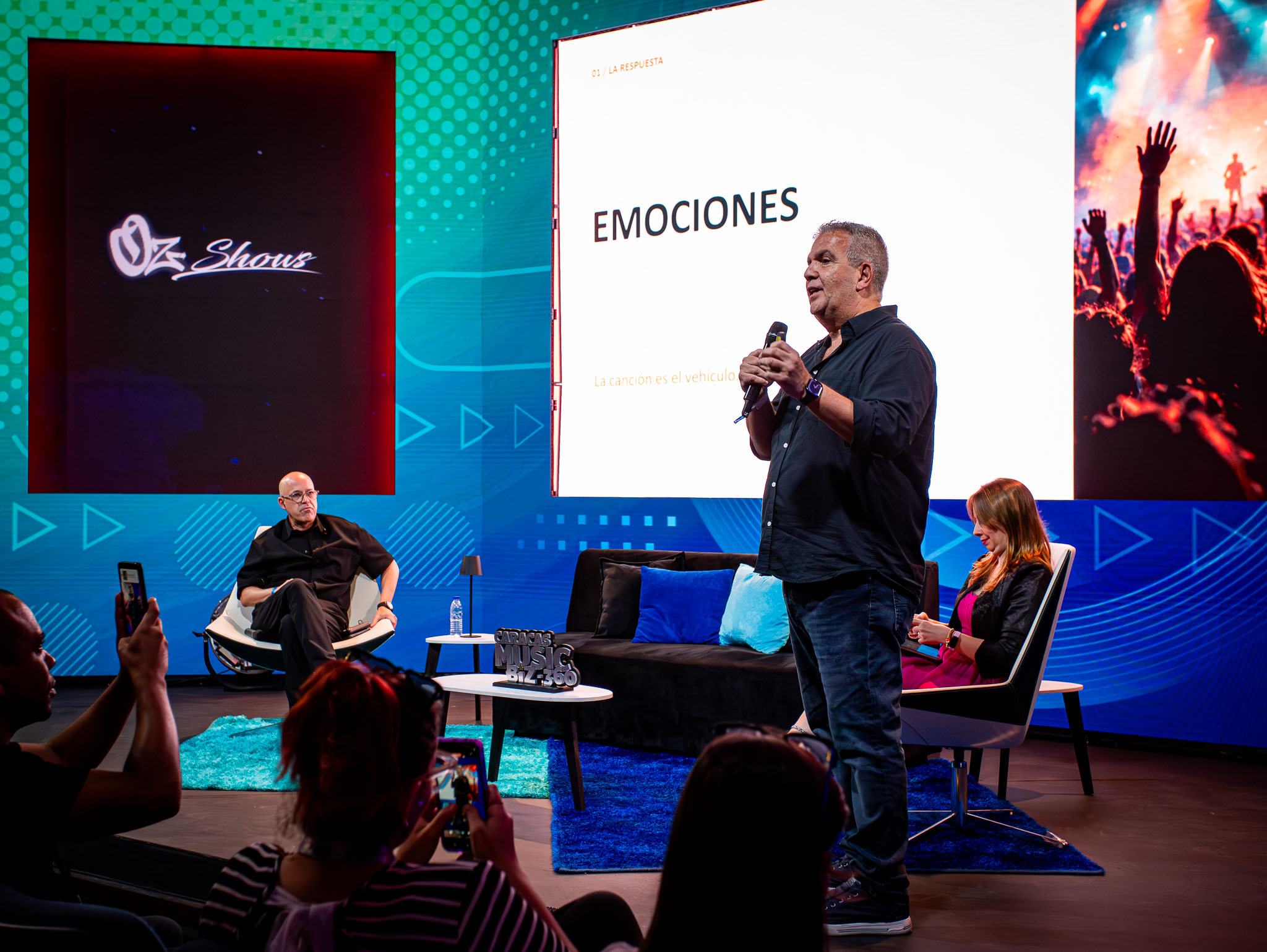 Marcelo Mazzini en el escenario de Caracas Music Biz 360, frente a la diapositiva Emociones y al público